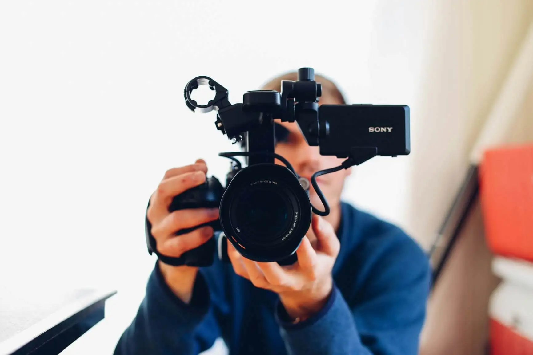 A man holding DSLR camera recording a video for B2B content strategy plans.
